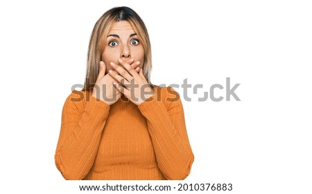 Young caucasian woman wearing casual clothes shocked covering mouth with hands for mistake. secret concept. 