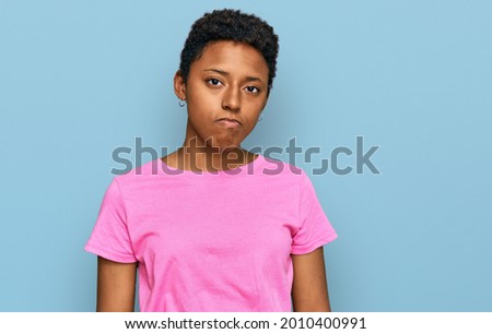 Young african american woman wearing casual clothes looking sleepy and tired, exhausted for fatigue and hangover, lazy eyes in the morning. 