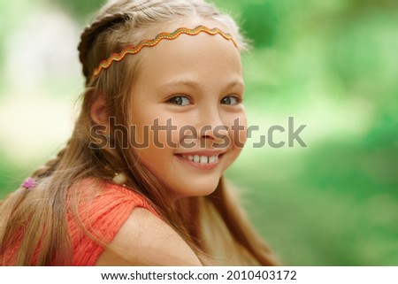 Happy child. Close-up portrait of a laughing happy girl child on a blurred summer background. 