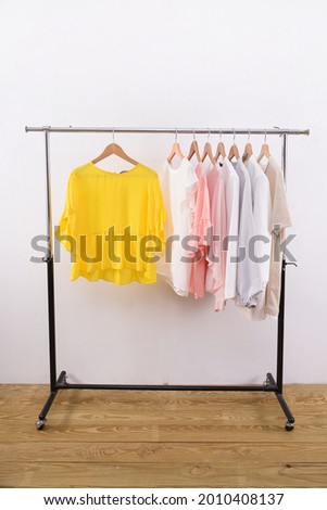 female different clothes with dress ,jacket, shirts , vest ,sweater blouses shirt with handbag on hanger