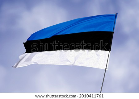 Estonia flag isolated on sky background. National symbol of Estonia. Close up waving flag with clipping path.