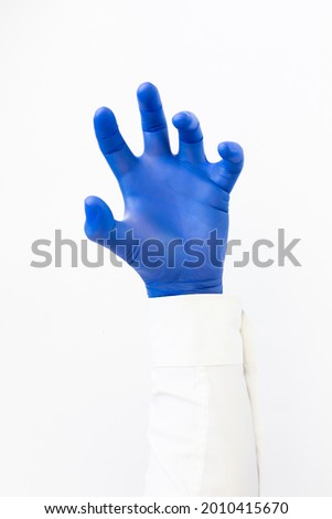 Hand in blue latex Glove grabing. Copy space, white background