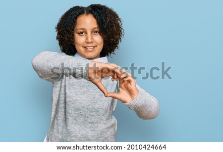 Young little girl with afro hair wearing casual clothes smiling in love doing heart symbol shape with hands. romantic concept. 
