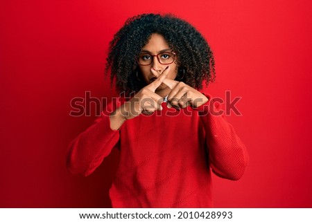 Beautiful african american woman with hair wearing sweater and glasses rejection expression crossing fingers doing negative sign 