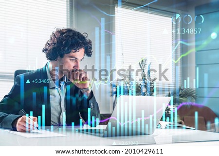 Handsome Hispanic financial trader analyzing stock graph chart and taking notes to predict the market rise, fundamental analysis, side view of working businessman. Internet trading Royalty-Free Stock Photo #2010429611