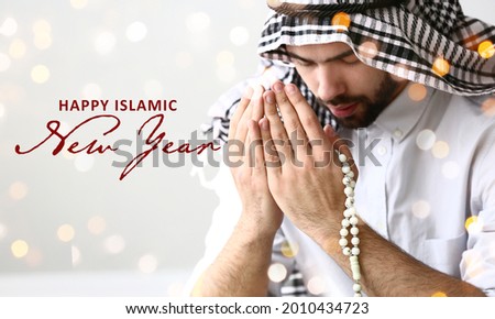 Young Muslim man praying on light background. Celebration of Islamic New Year Royalty-Free Stock Photo #2010434723