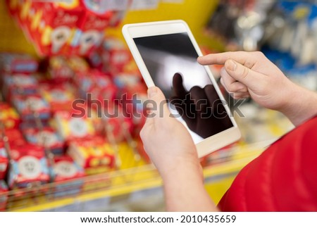 Male sales manager pointing at screen of digital tablet in his hand