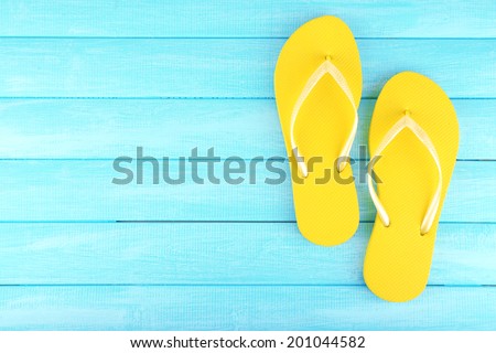 Bright flip-flops on color wooden background Royalty-Free Stock Photo #201044582