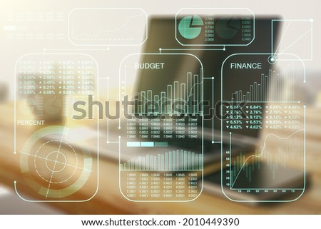 Multi exposure of creative statistics data hologram and modern desktop with laptop on background, stats and analytics concept