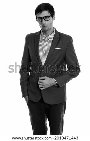 Studio shot of young handsome businessman in suit isolated against white background in black and white