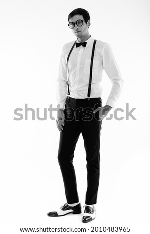 Studio shot of young handsome businessman isolated against white background in black and white