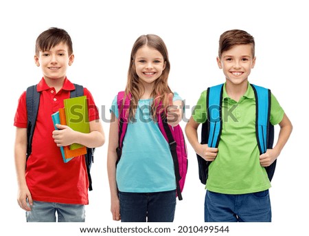 education, learning and people concept - group of happy smiling children with school bags showing thumbs up over white background