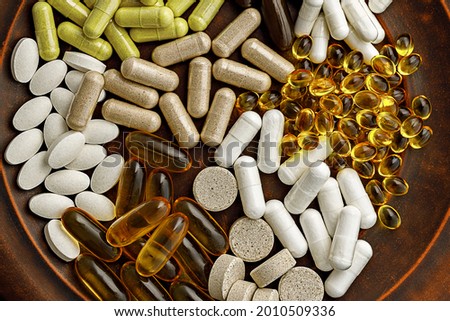 multivitamin dietary supplements on a clay plate. dietary supplements top view. mental wellbeing and personal health concept Royalty-Free Stock Photo #2010509336