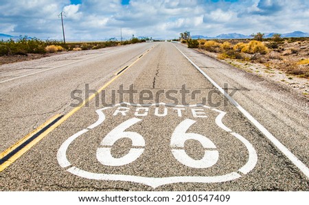 Route 66 road sign with blue sky background. Historic street with nobody. Classic concept for travel and adventure in a vintage way.