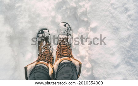 Winter hiking in Snow boots walking first person POV selfie of feet in deep cold snowfall in outdoors nature. Girl taking picture of her shoes.