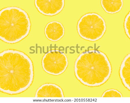 Slices of lemons on a yellow background. Seamless pattern.