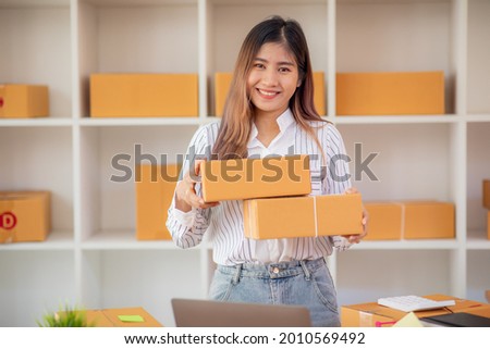 Starting Small business entrepreneur SME freelance,Portrait young woman working at home office, BOX,smartphone,laptop, online, marketing, packaging, delivery, SME, e-commerce concept