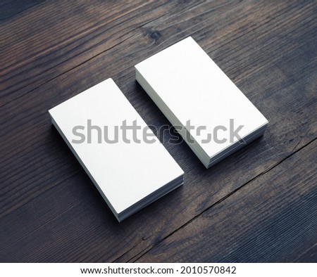 Two blank business cards on wood table background. Branding mockup.