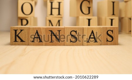 The word Kansas was created from wooden letter cubes. Cities and words. close up.