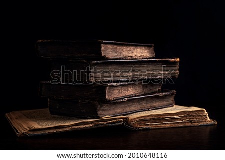 Stack of old worn shabby Jewish books in leather binding in the dark. Closeup. Selective focus. Low key Royalty-Free Stock Photo #2010648116