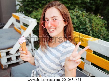Funny teen girl in cool hipster sunglasses eating ice cream cone