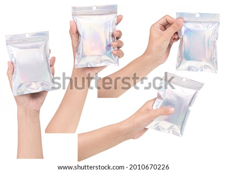 Set of hand holding Aluminum foil bag Plastic Laser Mylar Foil Zip Lock Bag isolated on white background. Royalty-Free Stock Photo #2010670226