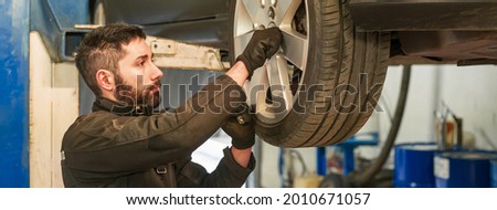 Mechanic repairs car, banner image with copy space