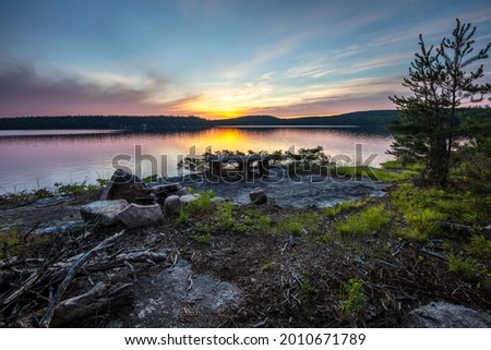 A campsite, complete with fire pit and a granite table top, on the shore of Eagle Lake, Northwest Ontario, Canada.