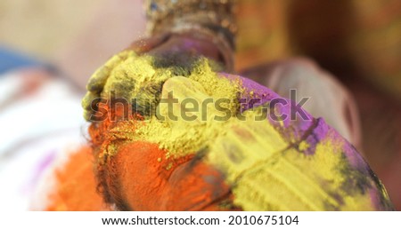 A closeup shot of an Indian beard man with a colorful face on the Festival of Colour