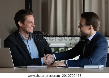 Two businessmen shaking hands at workplace. Client thanking lawyer, expert, advisor for consultation. Employer hiring candidate after job interview. Business partners closing deal with handshake Royalty-Free Stock Photo #2010700493