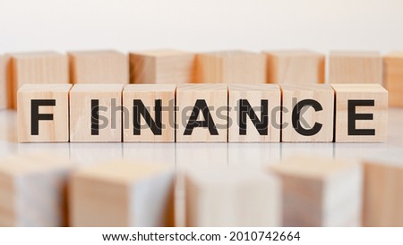 finance - wooden letters on the office desk, white background, business concept