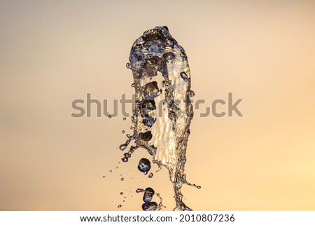 Drops of a falling water fountain against the evening sky. natural textures and backgrounds