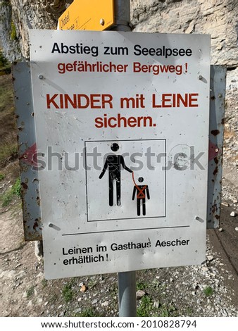 Safety sign translates to, "Descent to Seealpsee dangerous mountain path! Secure children with a leash. Leashes available at Guesthouse Aescher!"