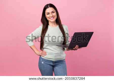 Photo of attractive charming young woman hold hands laptop waist smile isolated on pastel pink color background