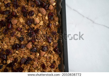 Baked nutty and cranberry granola on the tray freshly out from the oven,  Royalty-Free Stock Photo #2010838772