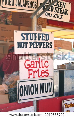 A vertical shot of fast food placards at a country fair