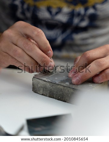 A vertical shot of a worker polishing a wooden ring