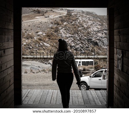 Girl walking through a door in the mountain