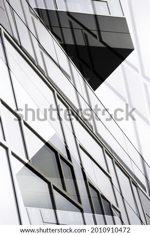 Double exposure photo of structural glazing. Windows of an office building with polygonal geometric pattern. Hi-tech framed glass exterior. Abstract modern architecture and material background.