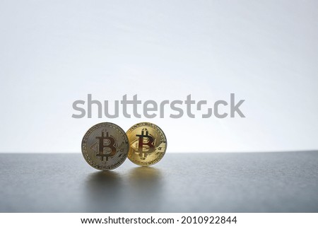 Bitcoins isolated on the white background.  Selective focus on the bitcoin at the front, creating a depth of field effect on the bitcoin at the back.