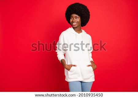 Photo of optimistic brunette hair young lady look empty space wear white sweatshirt isolated on red color background