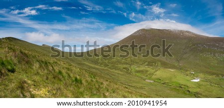 Mountains near Keem bay, county Mayo, Achill island, Ireland. Warm sunny day, Blue cloudy sky. Beautiful holiday destination with breathtaking view. Panorama image