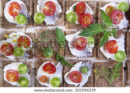 Presentation of slices of wholemeal bread with cheese and cherry tomatoes 