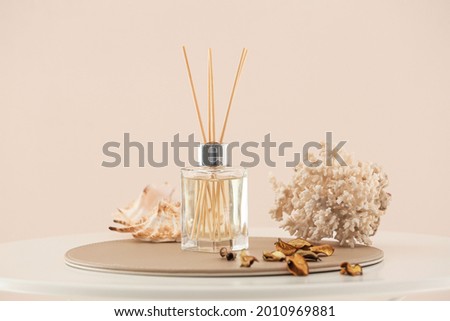 Reed diffuser and sea shells on table in room Royalty-Free Stock Photo #2010969881