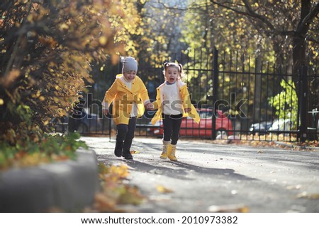 Children walk in the autumn park in the fall

