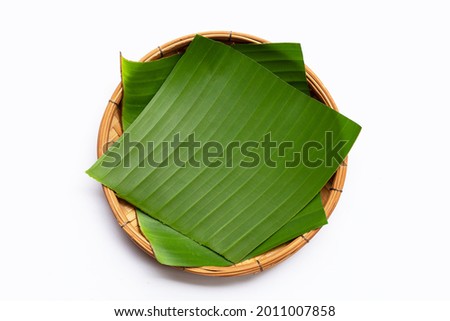 Banana leaves in bamboo basket on white background. Royalty-Free Stock Photo #2011007858