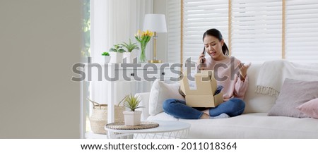 Upset mad asia people young girl consumer sit sofa at home open fake product order, damage post mail buy from online shopping retail store. Shock sad teen woman unbox from wrong bad shipping service. Royalty-Free Stock Photo #2011018364