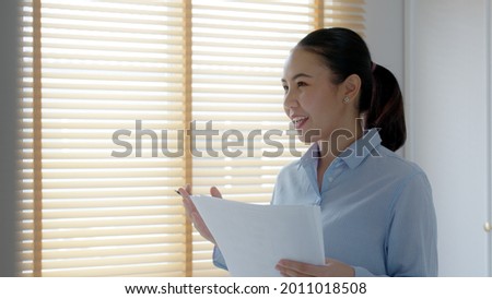 Young female leader, asia people lady or mba student happy standing smile look at in front of mirror pep talk for sale pitch hold paper document script public speak skill for job career self improve. Royalty-Free Stock Photo #2011018508
