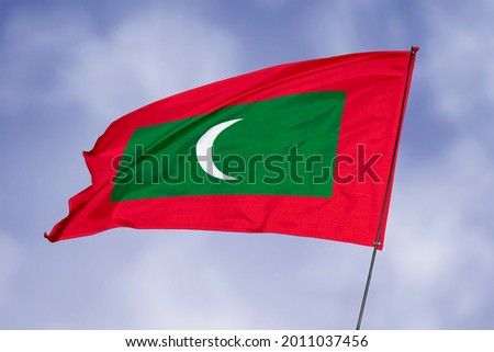 Maldives flag isolated on sky background. National symbol of Maldives. Close up waving flag with clipping path.