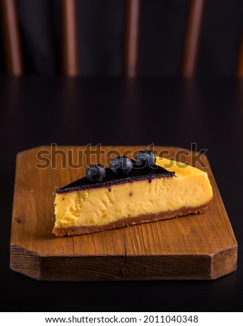 Lemon blueberry cheesecake on a dark background. Copy space